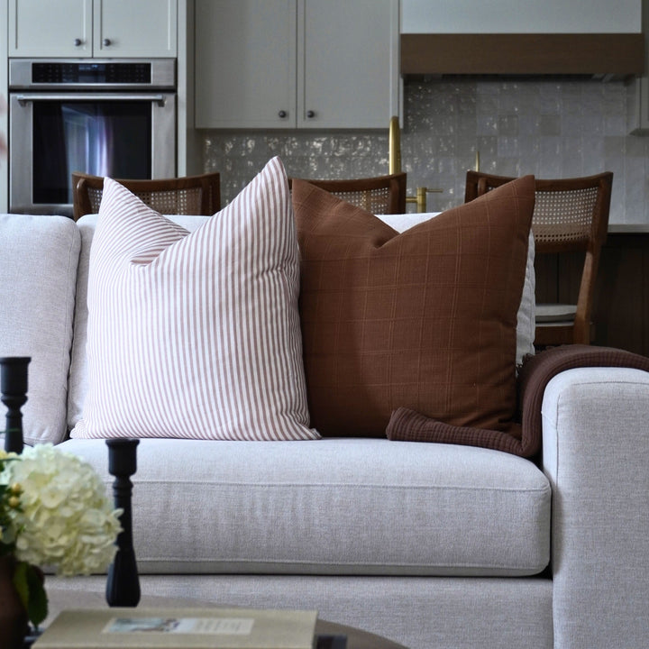 Gray sofa with decorative pillows in a modern living room setting.