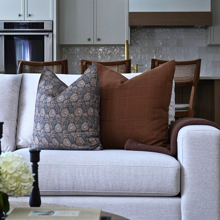 Gray sofa with patterned and brown cushions in a kitchen setting