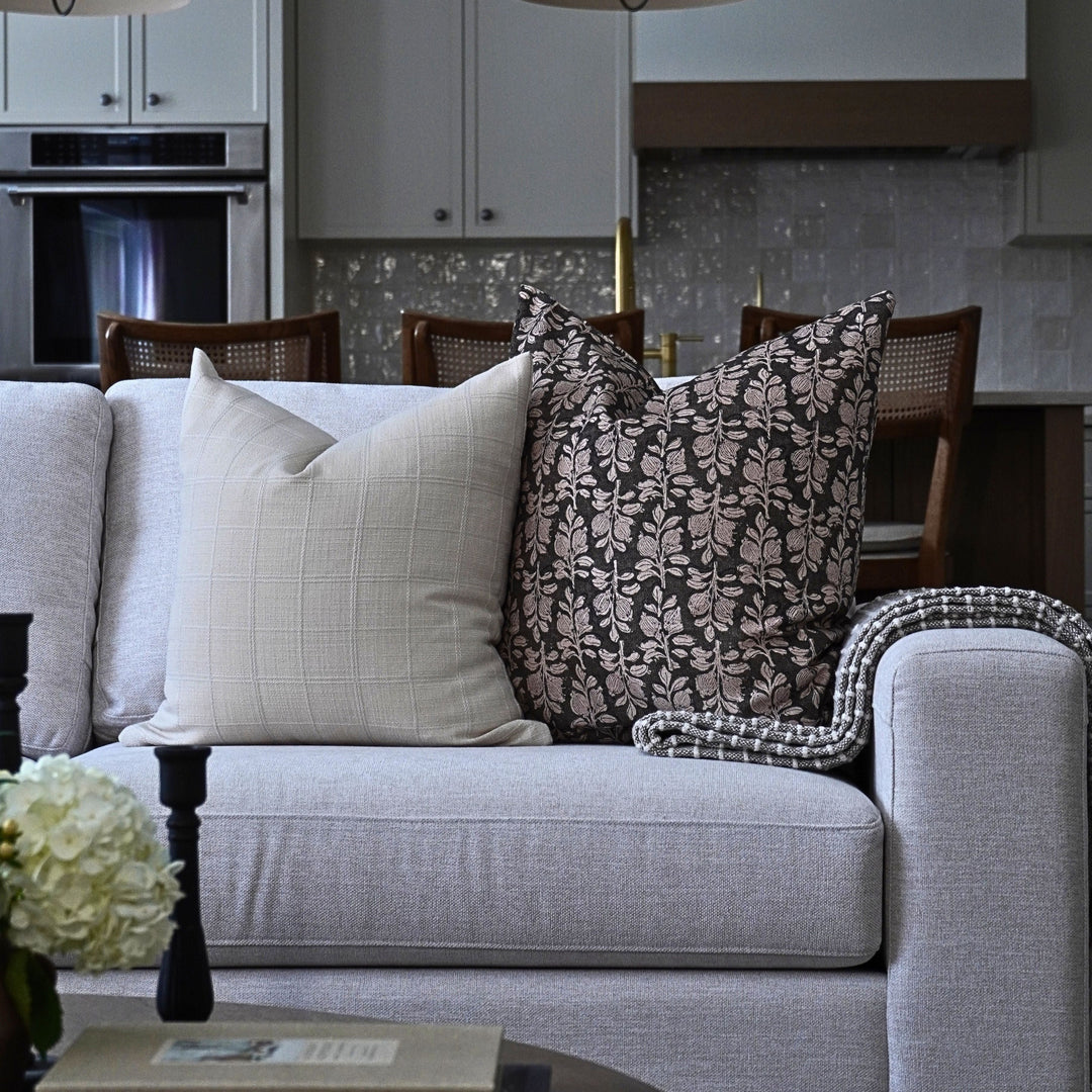Gray sofa with decorative pillows in a modern living room setting.