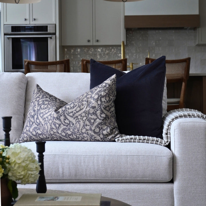 Gray sofa with decorative pillows in a living room setting.