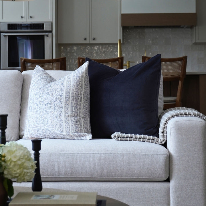Gray sofa with decorative pillows in a modern living room setting.
