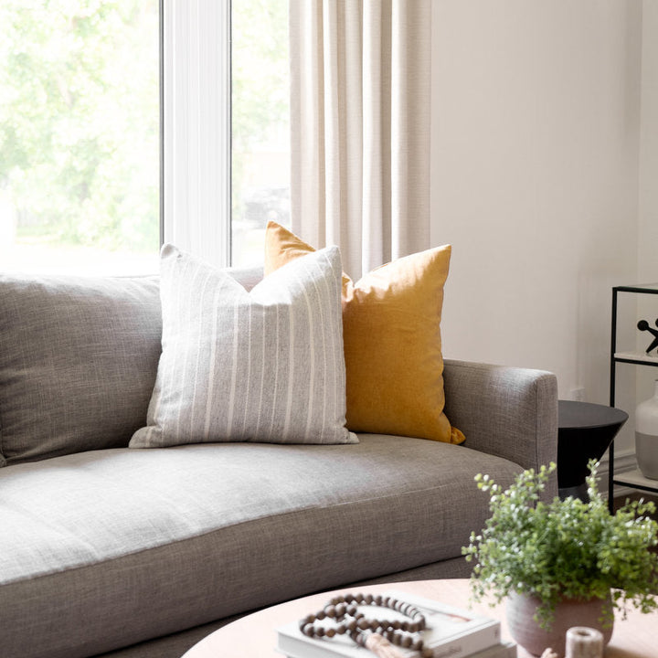 Gray sofa with yellow and white pillows in a bright living room.