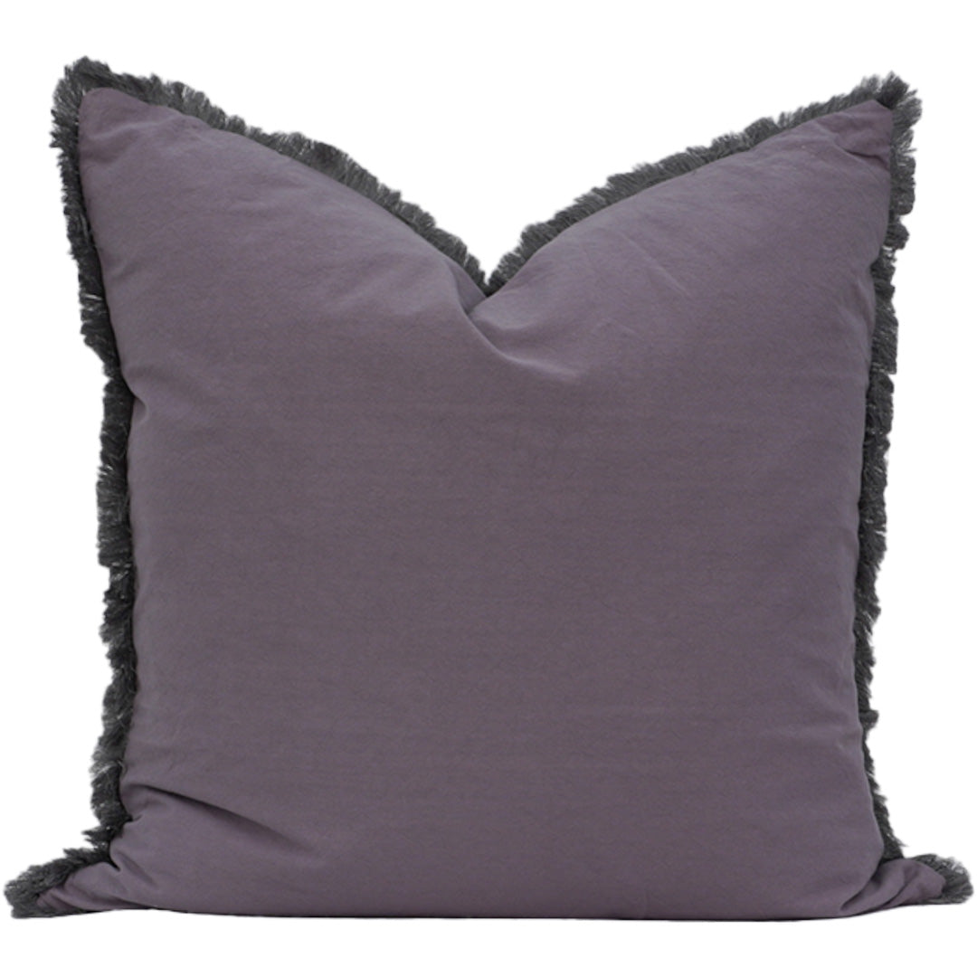 Grey pillow with black fringe on a white background