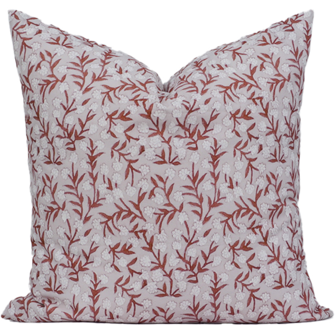 Decorative pillow with red floral pattern on a white background