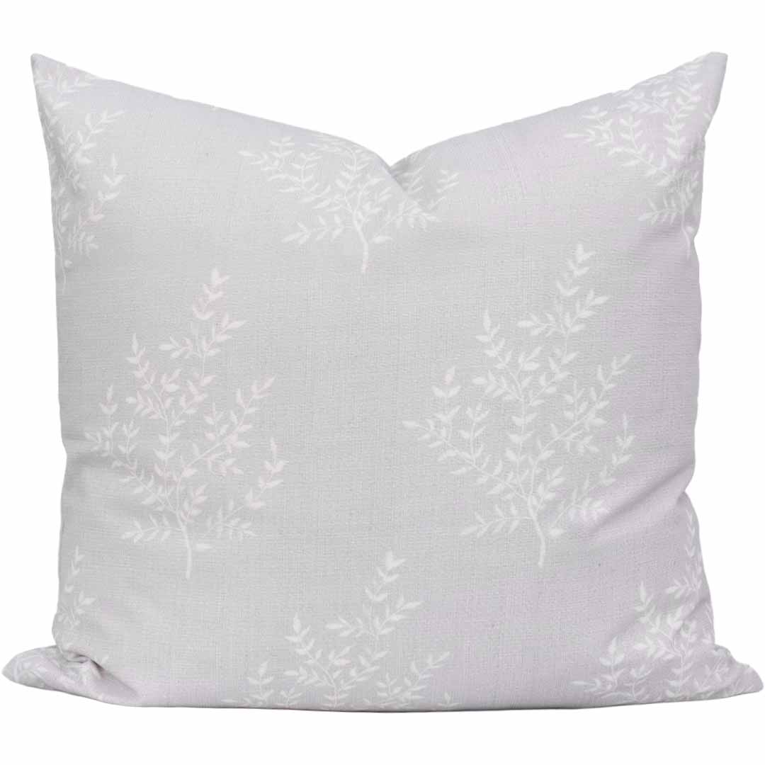 White pillow with subtle floral pattern on a white background
