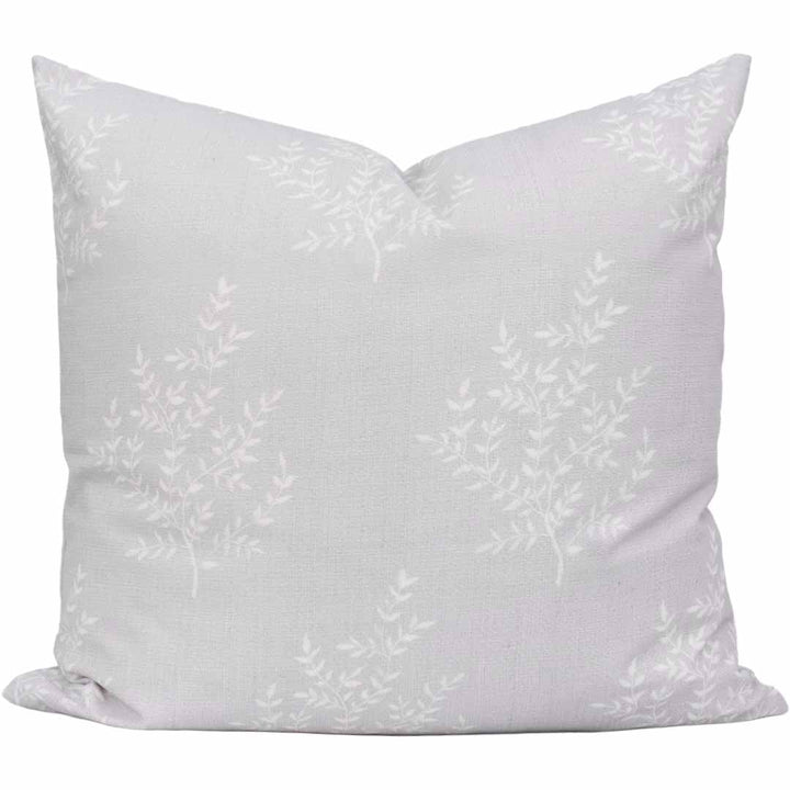 White pillow with subtle floral pattern on a white background